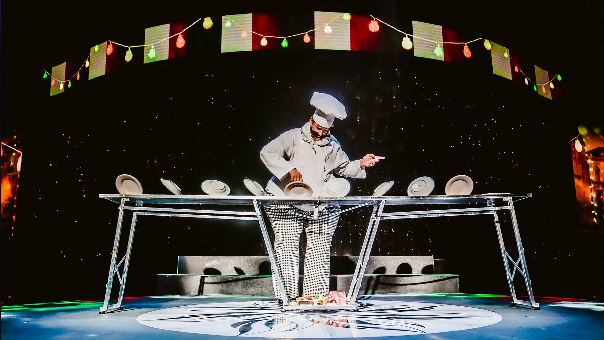 Chef performing plate-spinning act on stage at WOW The Vegas Spectacular